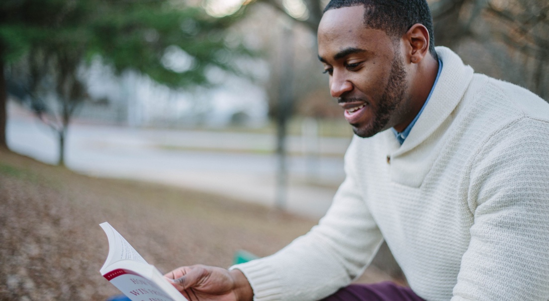 Student studying while holding the book upright